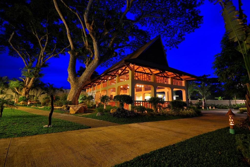 Munting Paraiso's bungalow building lit up in the evening, with the Deluxe Bungalow's private entrance