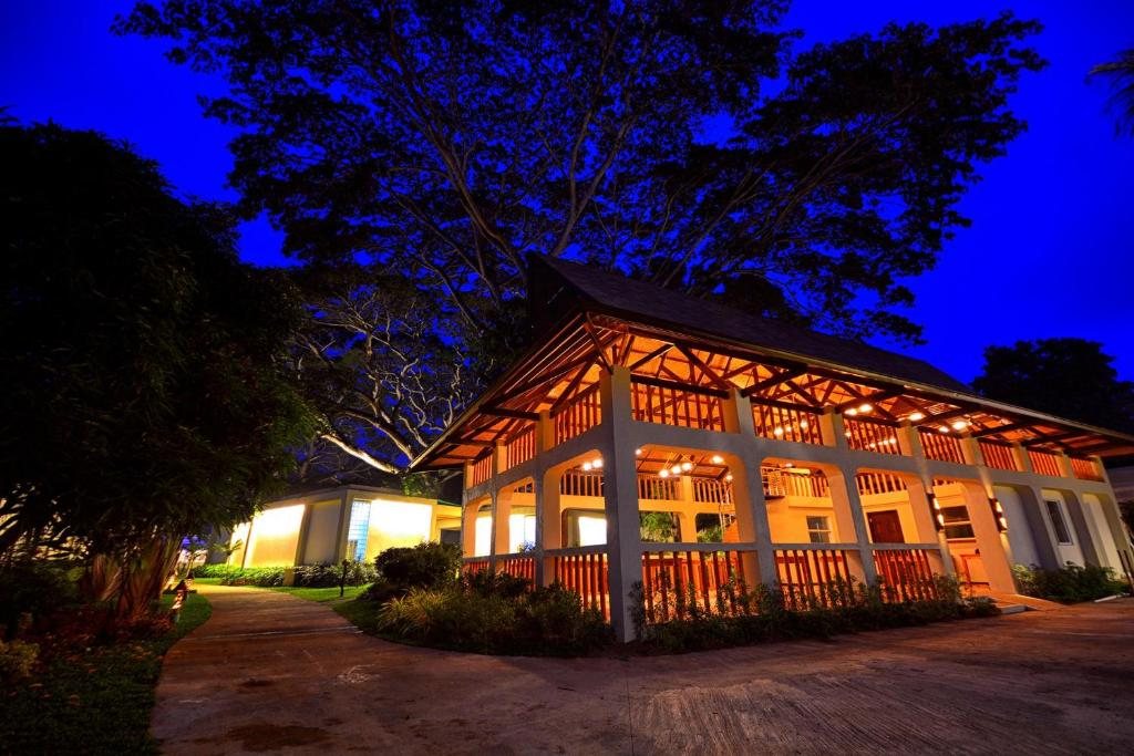 Two-story bungalow building at Munting Paraiso lit up against the evening sky