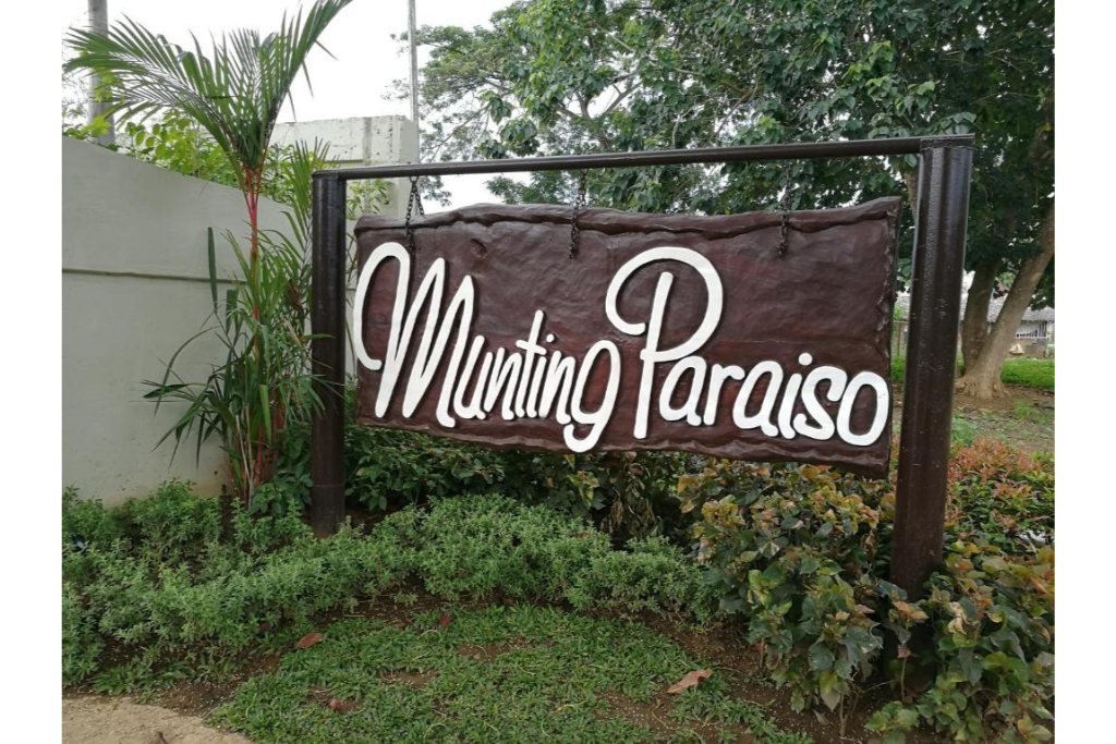 Munting Paraiso entrance sign surrounded by tropical garden landscaping